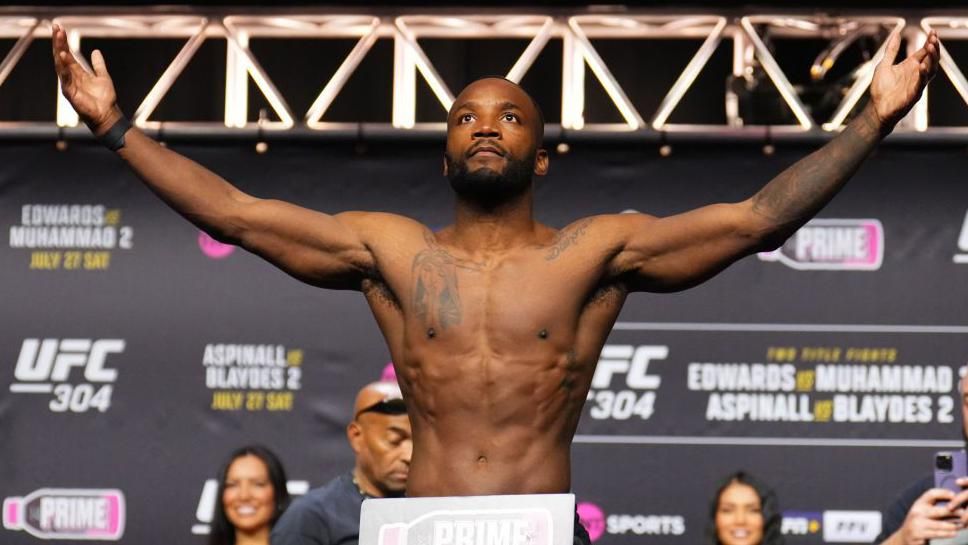 Leon Edwards weighs in with his arms stretched out 