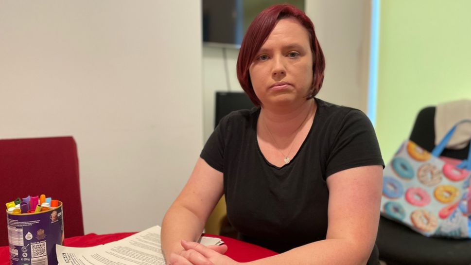 Sandy Simmons, sitting in her living room, looking directly at the camera.