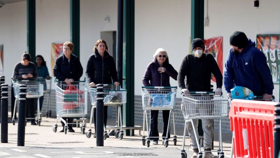 People queueing outside a supermarket