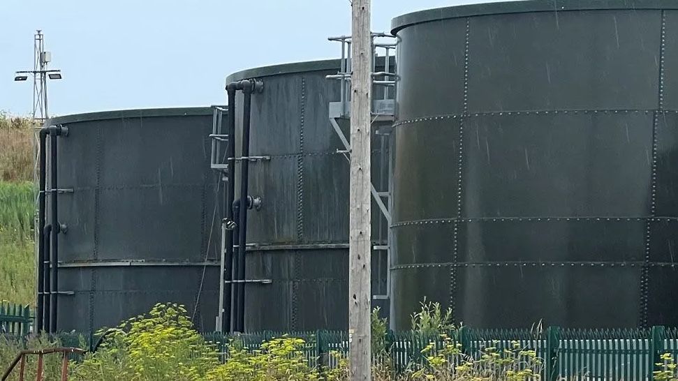 Three dark green waste tanks, owned by the company Transwaste