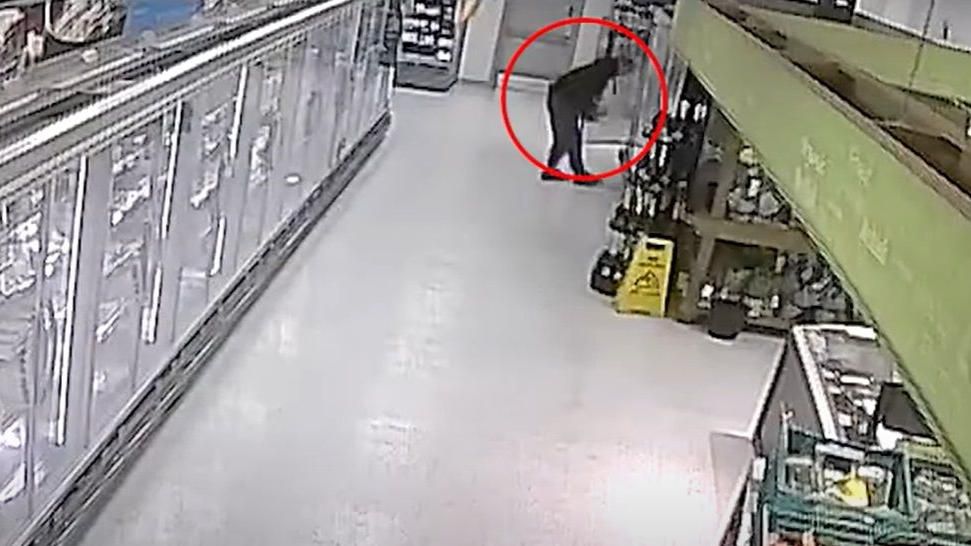 CCTV footage of man at an open fridge door removing items