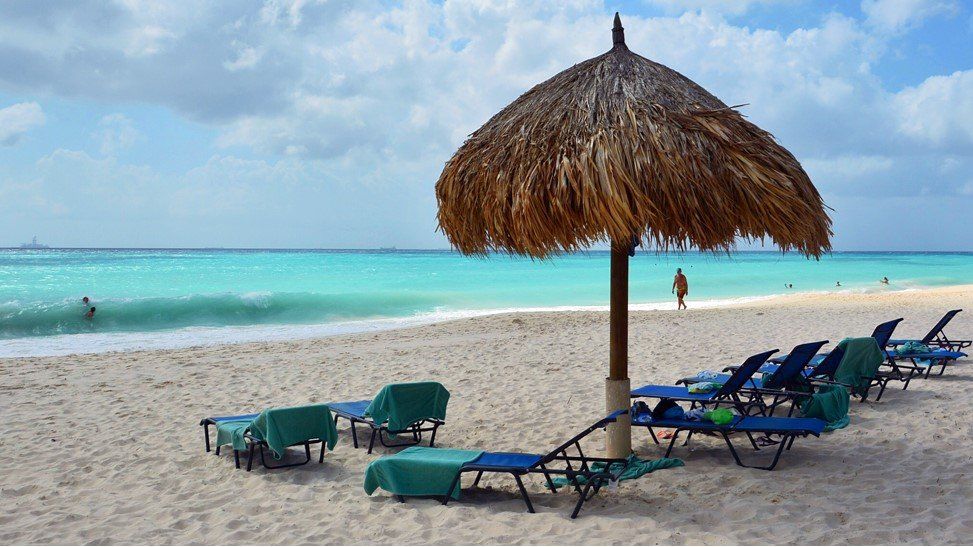 Lounge chairs and beach umbrella on a white sandy beach in Aruba