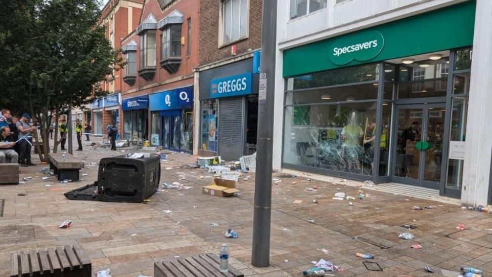 Hull high street with rubbish all over the floor and windows smashed including Specsavers and O2