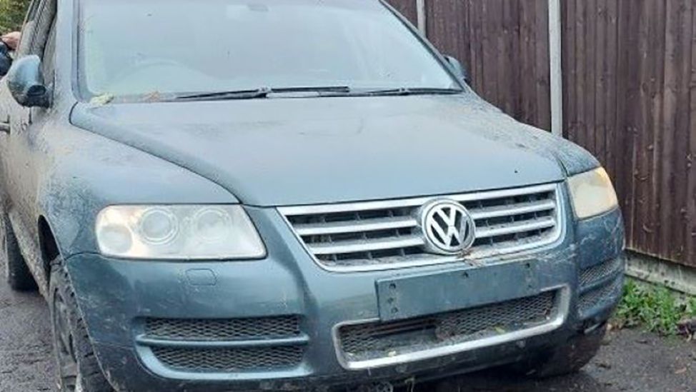 The men's seized car, a green VW Touareg, covered in mud