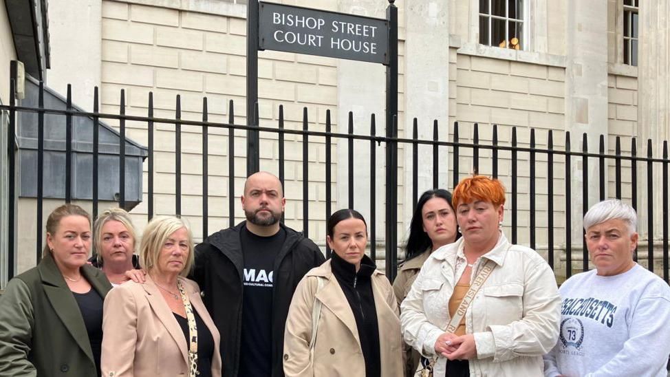 Shows members of the McLaughlin family standing outside Bishop Street courthouse in Derry