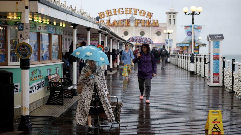 People walking on Brighton Palace Pier with umbrellas