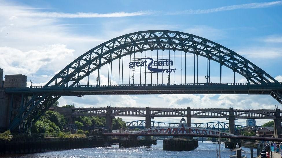 A view of the green Tyne Bridge with the Great North Run sign in the middle.