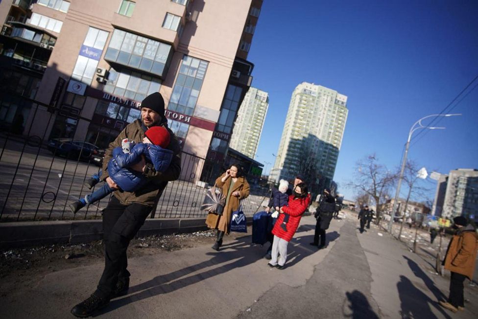 People evacuate the area after an attack on a residential building during Russia's military intervention in Kyiv, Ukraine on February 26, 2022.