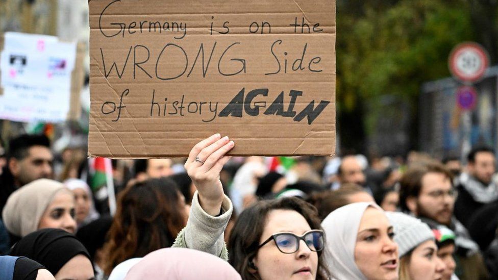 A woman holds a sign reading: "Germany is on the wrong side of history again" at a pro-Palestinian rally in Berlin