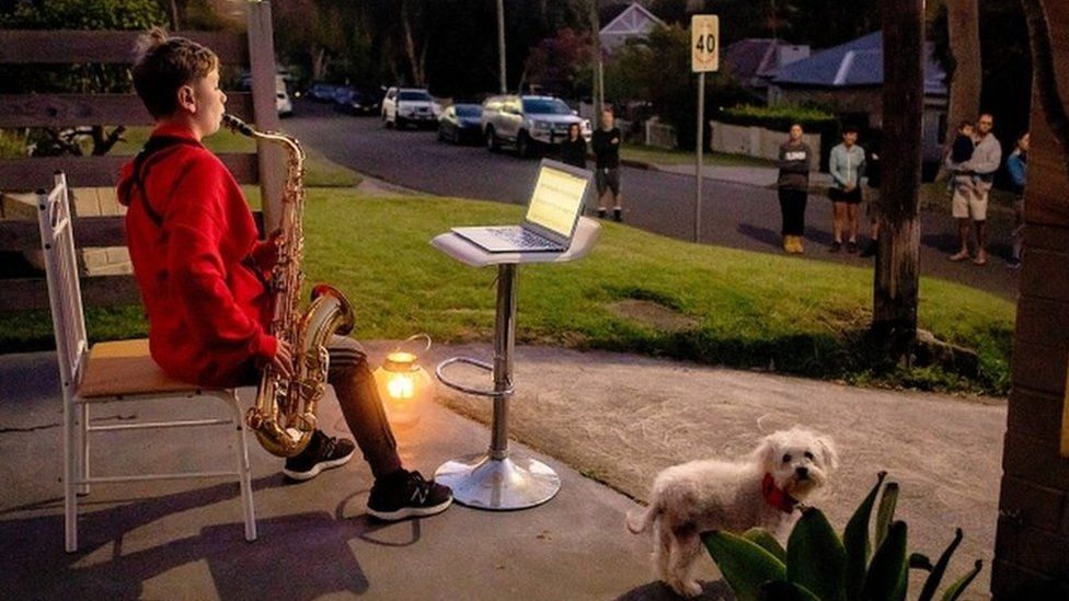 Jude Fell, aged 10, plays The Last Post on a saxophone from his driveway at dawn in Sydney on April 25, 2020
