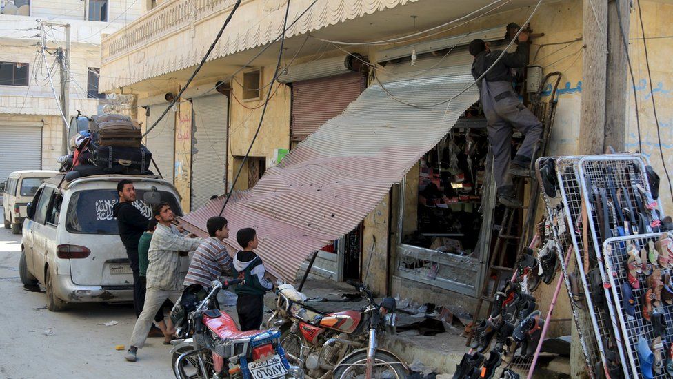 People work to fix a damaged shop in Darat Izza, Aleppo province, 28 February
