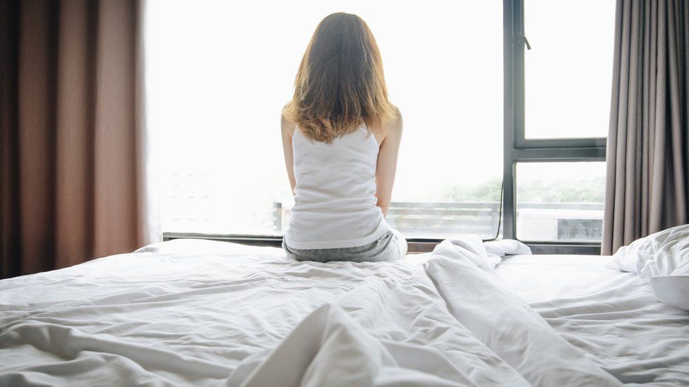 Stock image of a woman on a bed