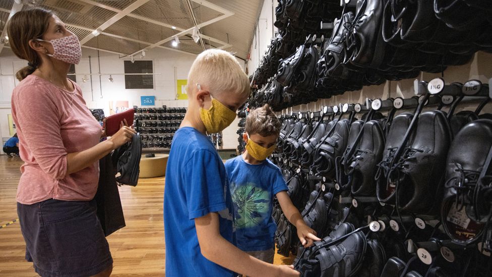 A mother and sons buying shoes at a Clarks shoes outlet in Somerset