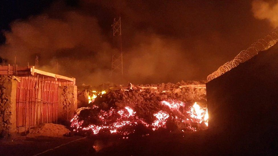 Flowing lava from the volcanic eruption of Mount Nyiragongo, which occurred late on 22 May 2021, is seen between buildings in Goma, Democratic Republic of Congo, in this still image from undated video obtained via social media