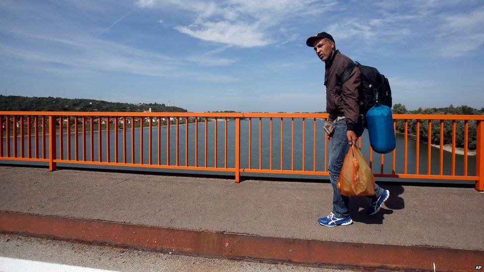 A migrant walks on road bridge over the Danube river between Serbia and Croatia, near Batina, Croatia, Thursday, Sept. 17, 2015