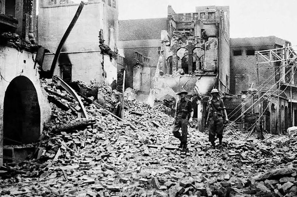 This photo taken in August 1947 shows Indian soldiers walking through the debris of a building in the Chowk Bijli Wala area of Amristar during unrest following the Partition of India and Pakistan
