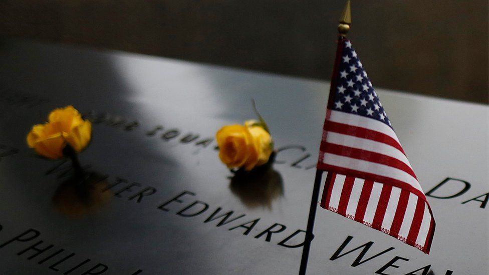 An American flag stands amongst names on the 9/11 memorial before the start of the 15th anniversary memorial service to 9/11 victims in New York, New York, USA,