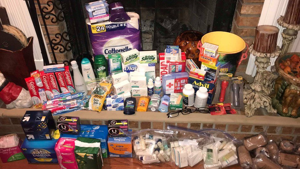 A pile of donated goods including toothpaste, first aid supplies, torches, toilet paper and more