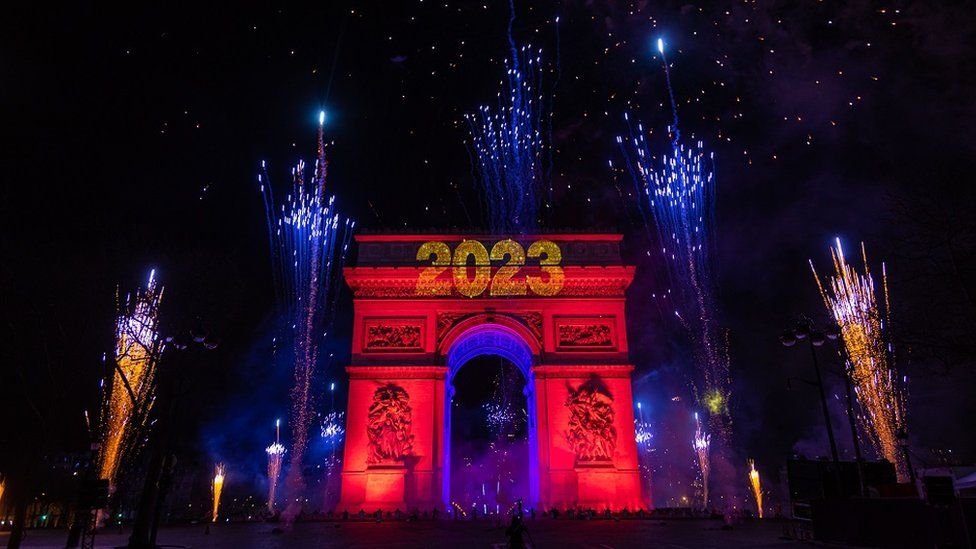 Световое шоу и фейерверк у Триумфальной арки, когда гуляки празднуют Новый 2023 год на Елисейских полях в Париже, Франция, 1 января 2023 года.