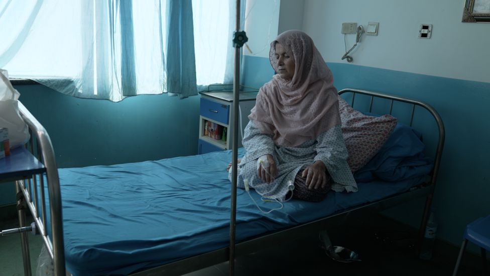 Mazaria sits on a bed in a cancer ward in Kabul