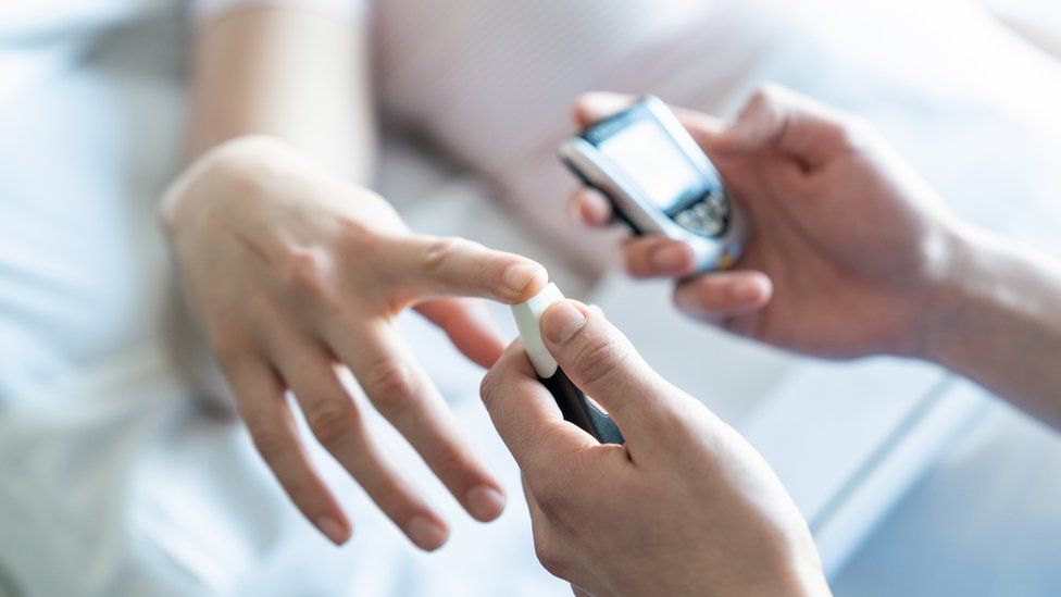 A patient having their blood sugar levels checked