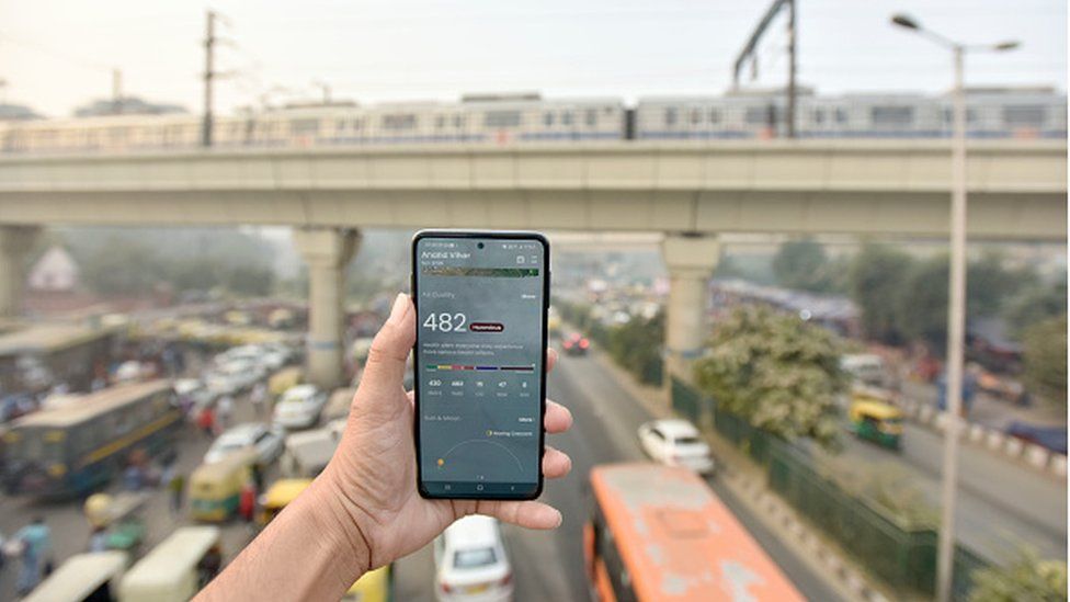 Смартфон показывает городской индекс качества воздуха (AQI) с веб-сайта Центрального совета по контролю за загрязнением (CPCB). Уровни загрязнения поднялись до критической категории рано утром в воскресенье возле ISBT Ананд Вихар, 30 октября 2022 г. в Нью-Дели,