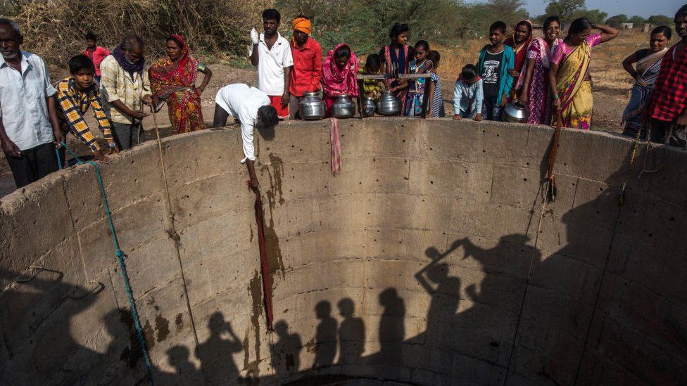Villagers from Nandi village in Maharashtra fill water from a well with a low water level in March 2019