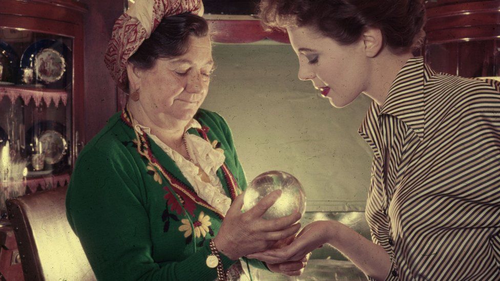 A gypsy fortune teller looking at a crystal ball c.1970
