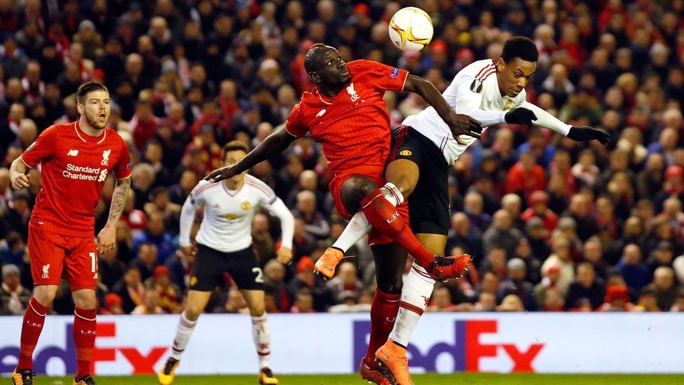 Liverpool’s Mamadou Sakho jumps for the ball with United’s Anthony Martial, right, during the Europa League round of 16, first leg