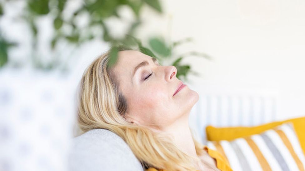 Woman with eyes closed leaning back on chair