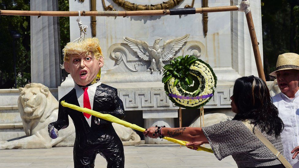 A woman hits a pinata of Donald Trump during a protest in Mexico City, on October 12, 2016