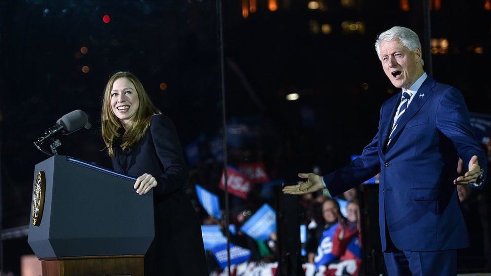 Chelsea Clinton delivering a speech, supported by her father Bill Clinton