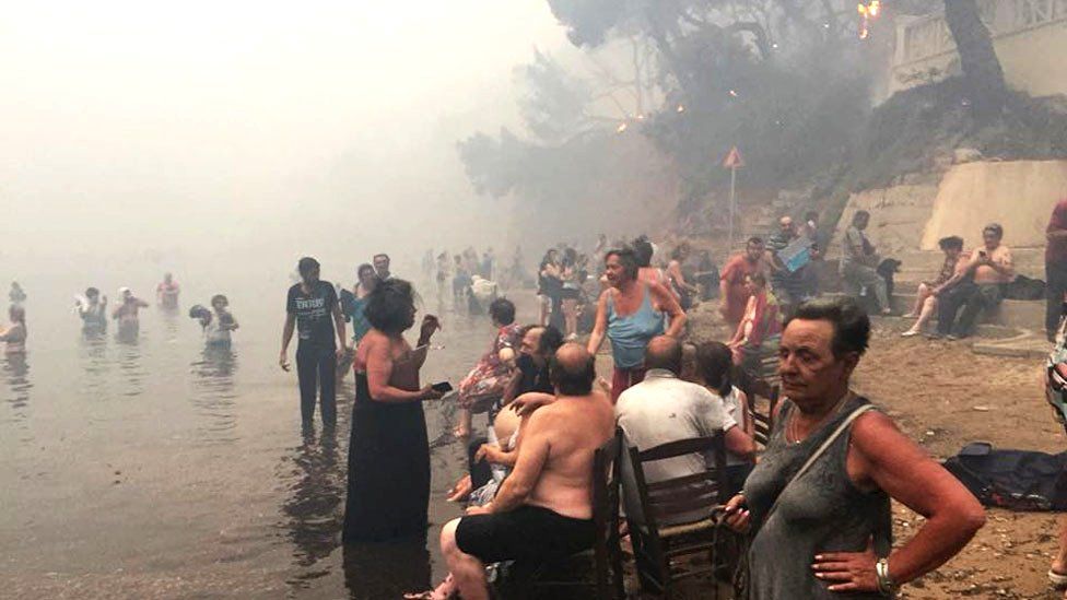 People escape the wildfires in Greece by heading to the beach