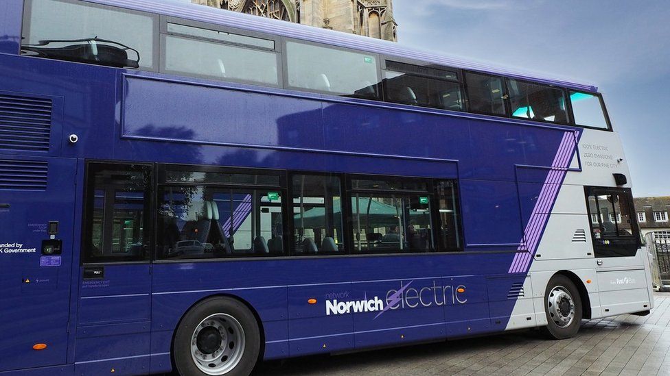 Electric bus parked in Norwich. The bus is dark blue and white at the front