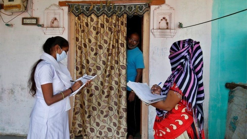 Health workers collect personal data from a man as they prepare a list during a door-to-door survey for the first shot of COVID-19 vaccine for people above 50 years of age and those with comorbidities, in a village on the outskirts of Ahmedabad, India, December 14, 2020.