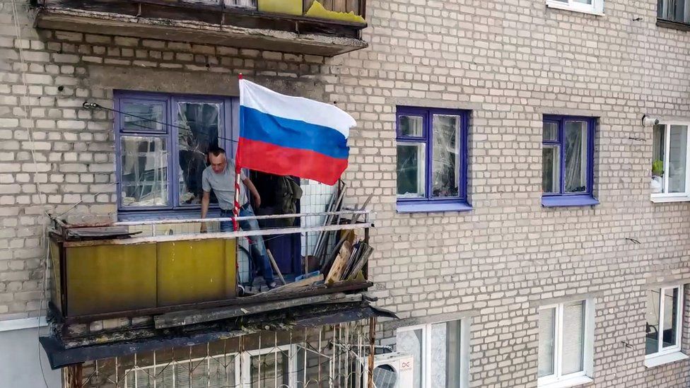 Image shows Russian flag waving from balcony