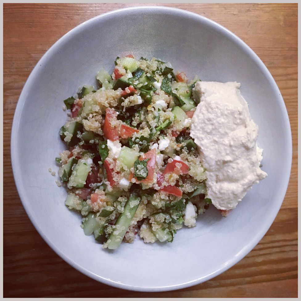 A salad with quinoa, tomatoes, cucumber, feta, mint and parsley