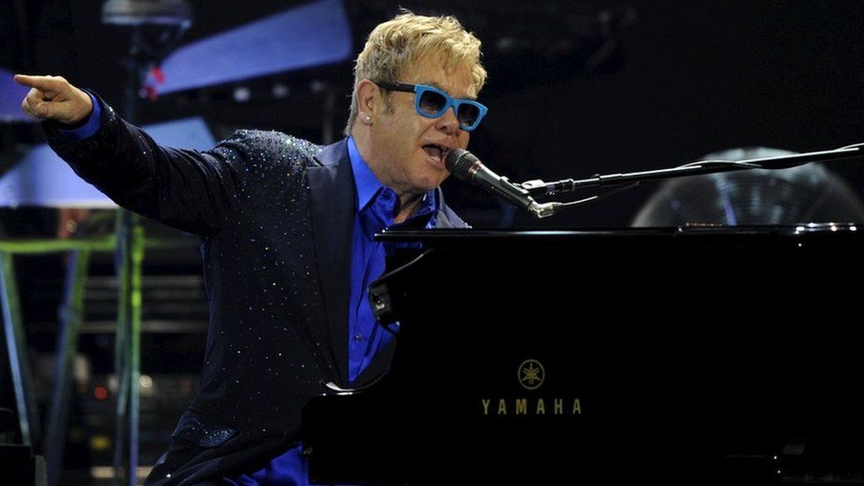 British singer-songwriter Elton John performs with his band during a concert in Gijon, July 17, 2015
