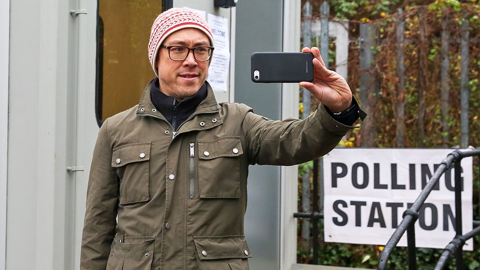 A person takes a selfie at a polling station in London in 2019