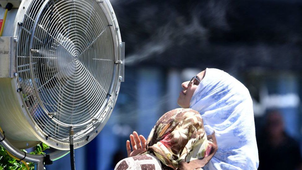 Two women in front of an outdoor fan