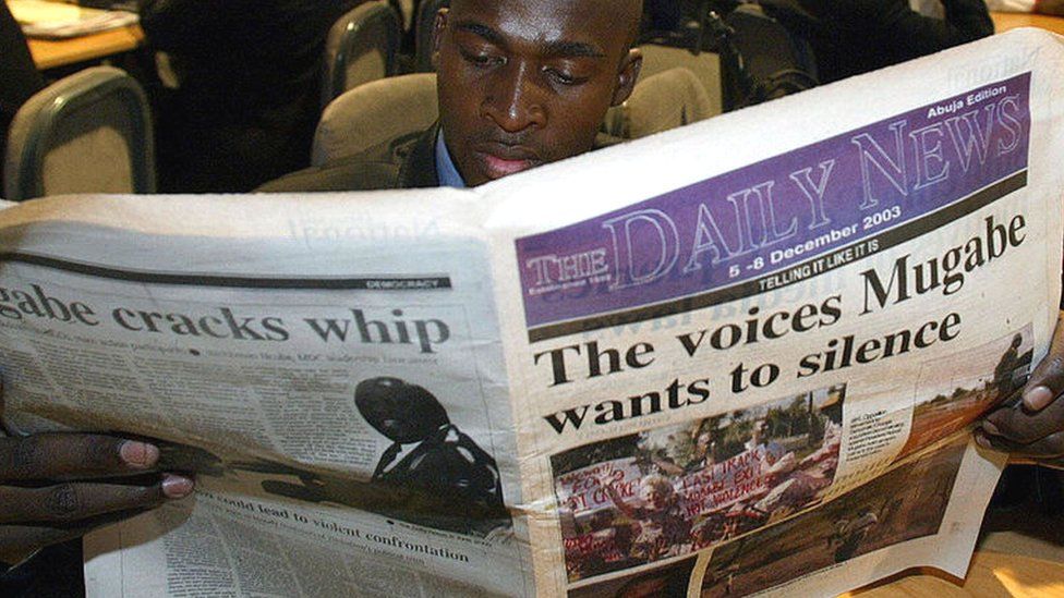 Jemand liest eine Sonderausgabe der Daily News auf dem Commonwealth-Gipfel in Abuja, Nigeria - Dezember 2003