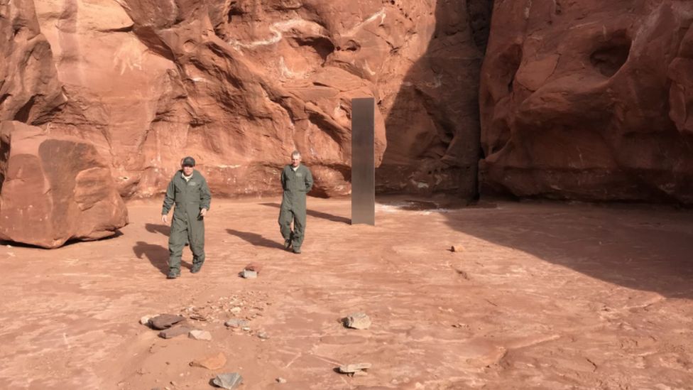 Wildlife officials walking away from the monolith