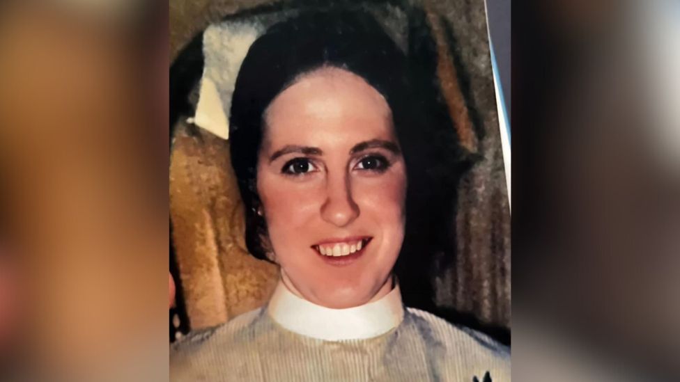 A smiling 18-year-old Marian Bottjer dressed in her nursing uniform looks directly at the camera