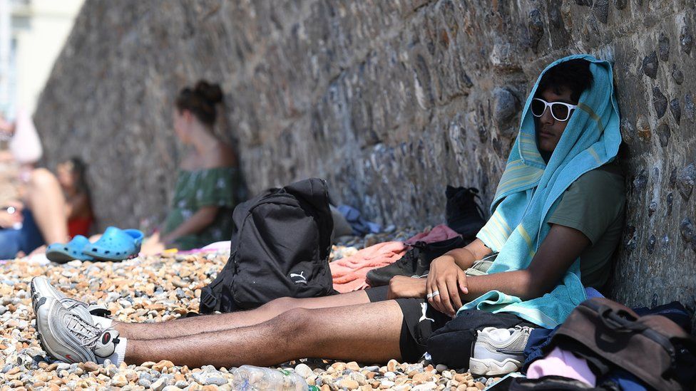 A man in the shade on Brighton beach