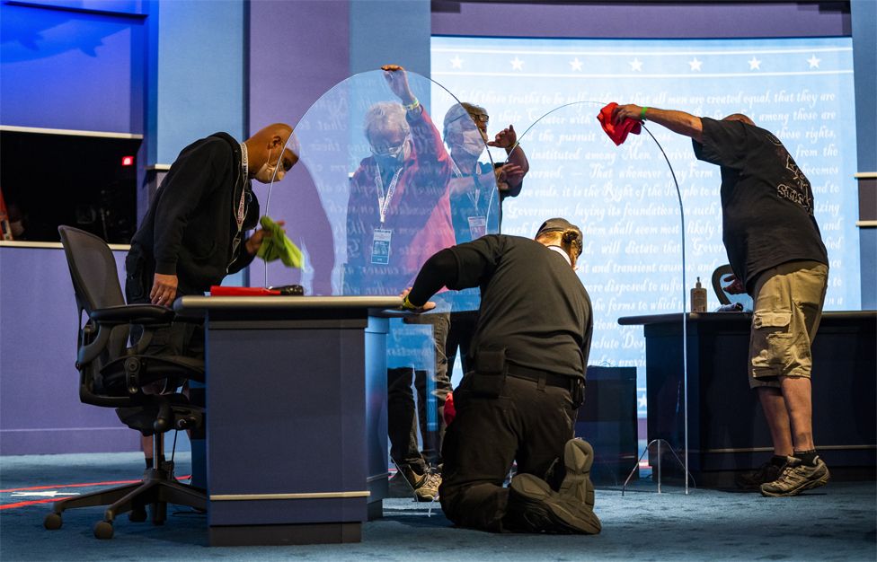 Workers prepare plexiglass on stage before the Vice President debate