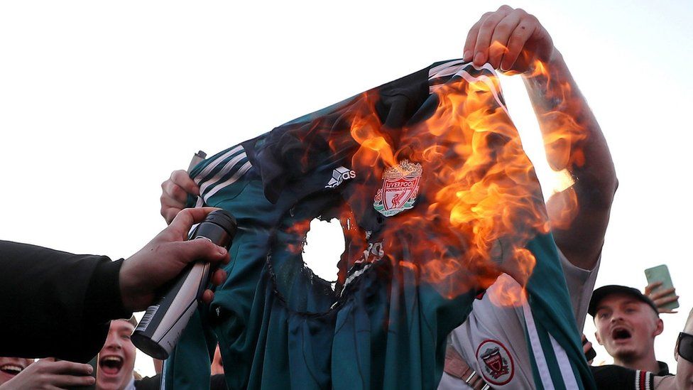 Fans burn a Liverpool replica shirt outside Elland Road against Liverpool's decision to be included amongst the clubs attempting to form a new European Super League