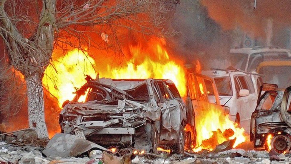 Wrecked cars burn at the scene of a terror attack in Mogadishu