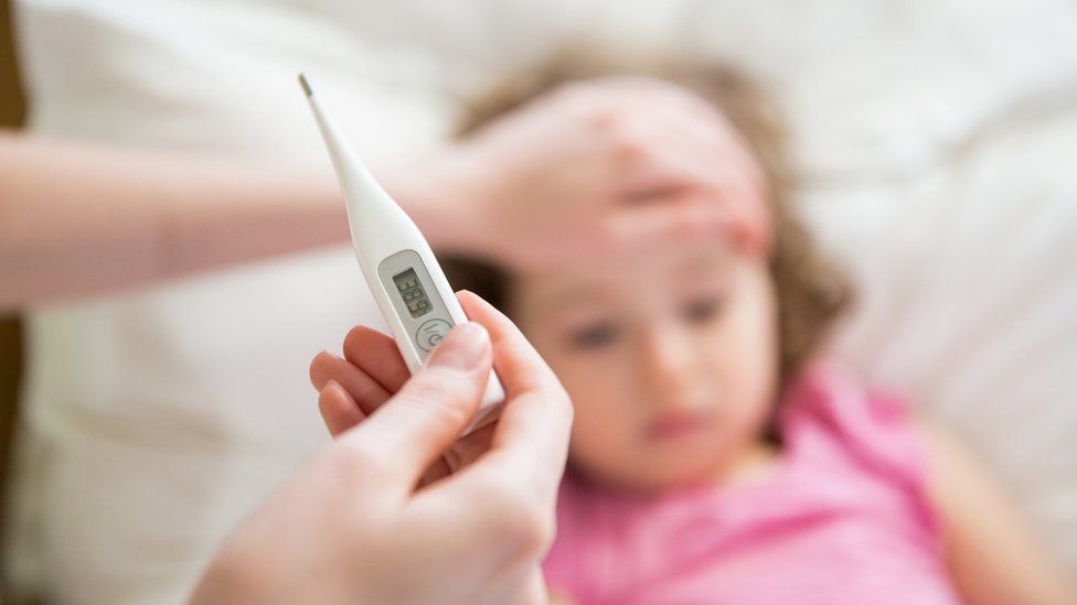 Close-up thermometer. Mother measuring temperature of her ill child