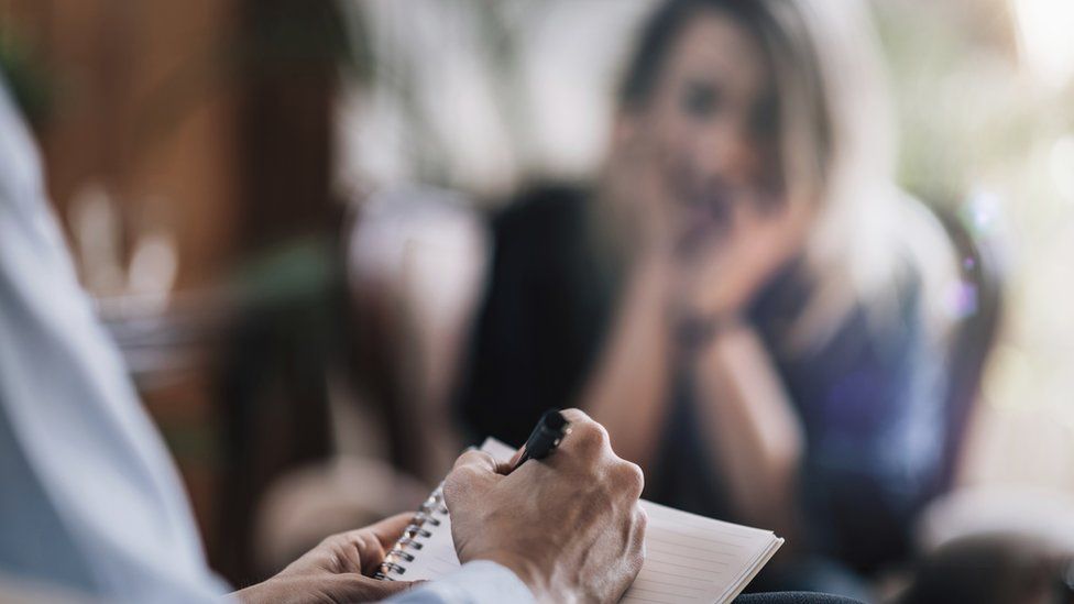 woman in therapy, therapist taking notes