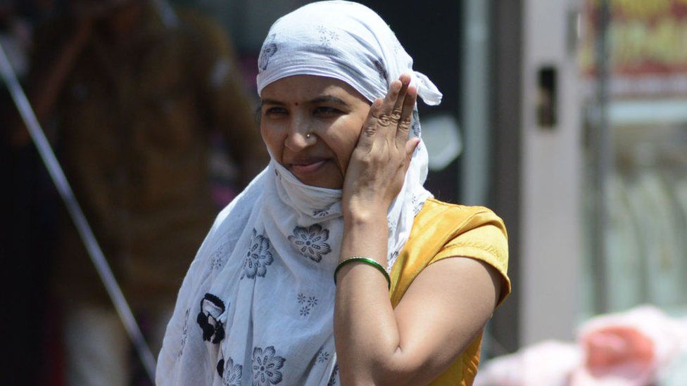 A woman covers her head with a scarf in the harassing and scorching afternoon heat as mercury rises in the city, Thane, on April 27, 2022 in Mumbai, India.
